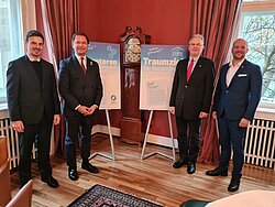 Franz Krämer und Carl Grouwet von der FDP mit VDFU-Präsident Friedhelm Freiherr von Landsberg-Velen und Jürgen Gevers vom VDFU vor zwei Plakaten.